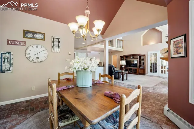 a dining room with furniture a large window and a chandelier