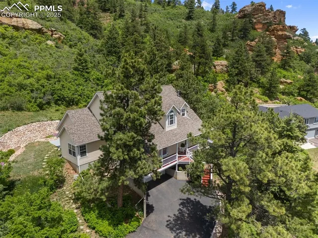 an aerial view of a house with a yard and trees