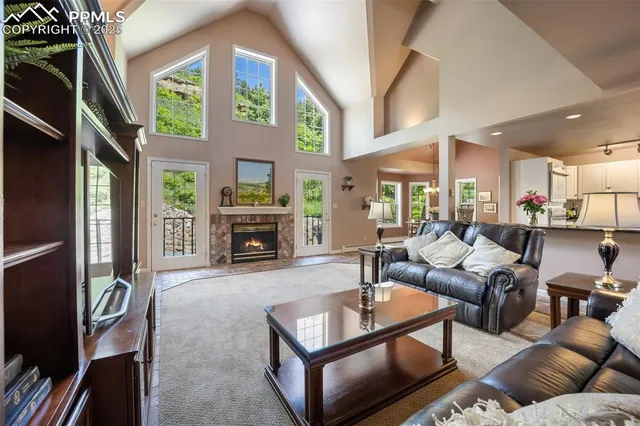 a living room with furniture a fireplace and a large window