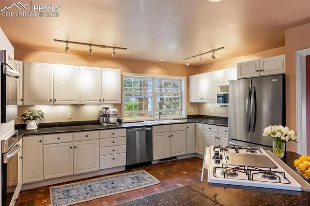 a kitchen with stainless steel appliances granite countertop a sink stove and refrigerator