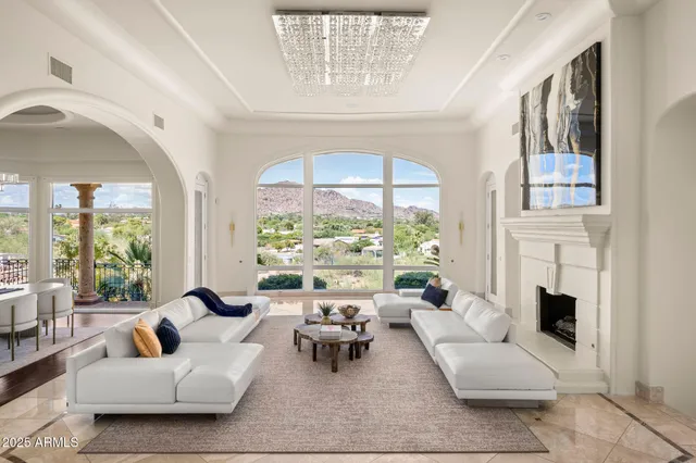 a living room with furniture fireplace and a large window
