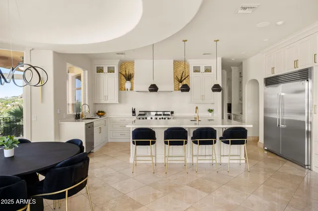 a kitchen with stainless steel appliances granite countertop a sink a stove and a refrigerator