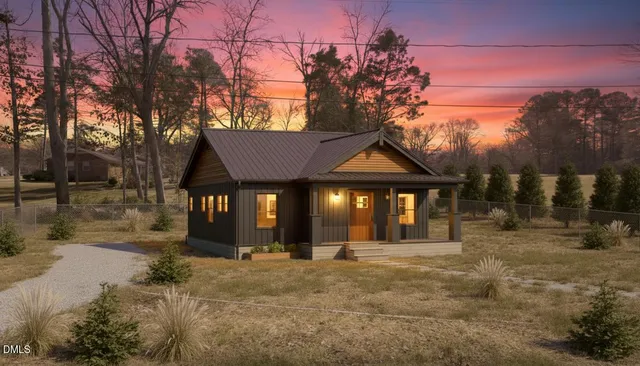 a front view of a house with yard and trees