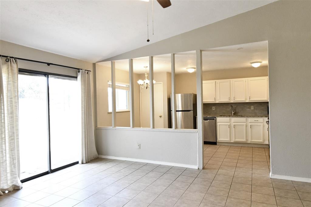 4113 Juneberry Street Fort Worth, TX 76137 - Photo 18 of 36 a view of a kitchen with a refrigerator and white cabinets
