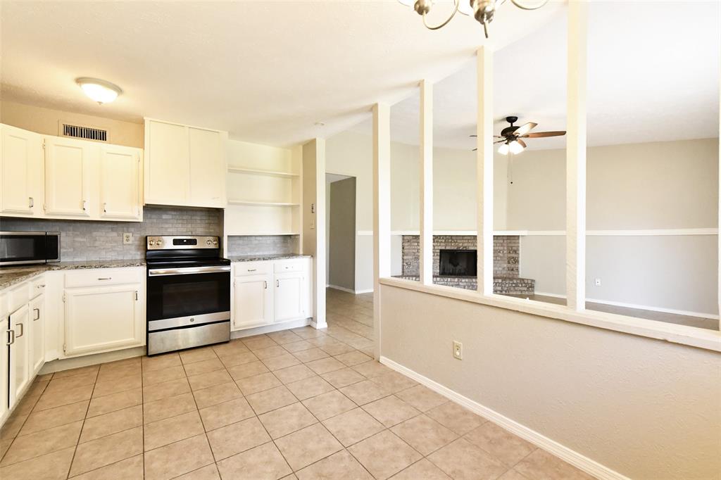 4113 Juneberry Street Fort Worth, TX 76137 - Photo 19 of 36 a kitchen with granite countertop a stove and a refrigerator