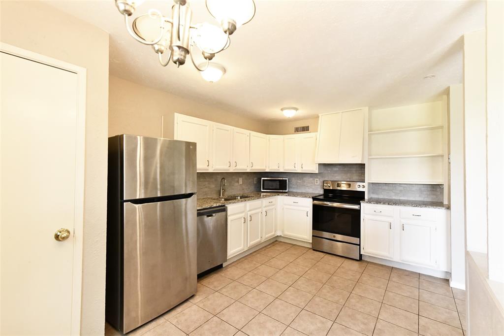 4113 Juneberry Street Fort Worth, TX 76137 - Photo 22 of 36 a kitchen with a refrigerator a stove top oven and cabinets