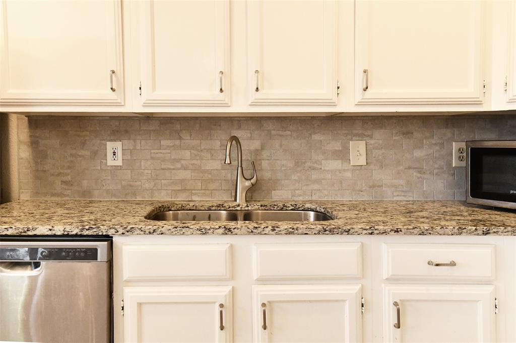 4113 Juneberry Street Fort Worth, TX 76137 - Photo 23 of 36 a kitchen with granite countertop white cabinets and a sink