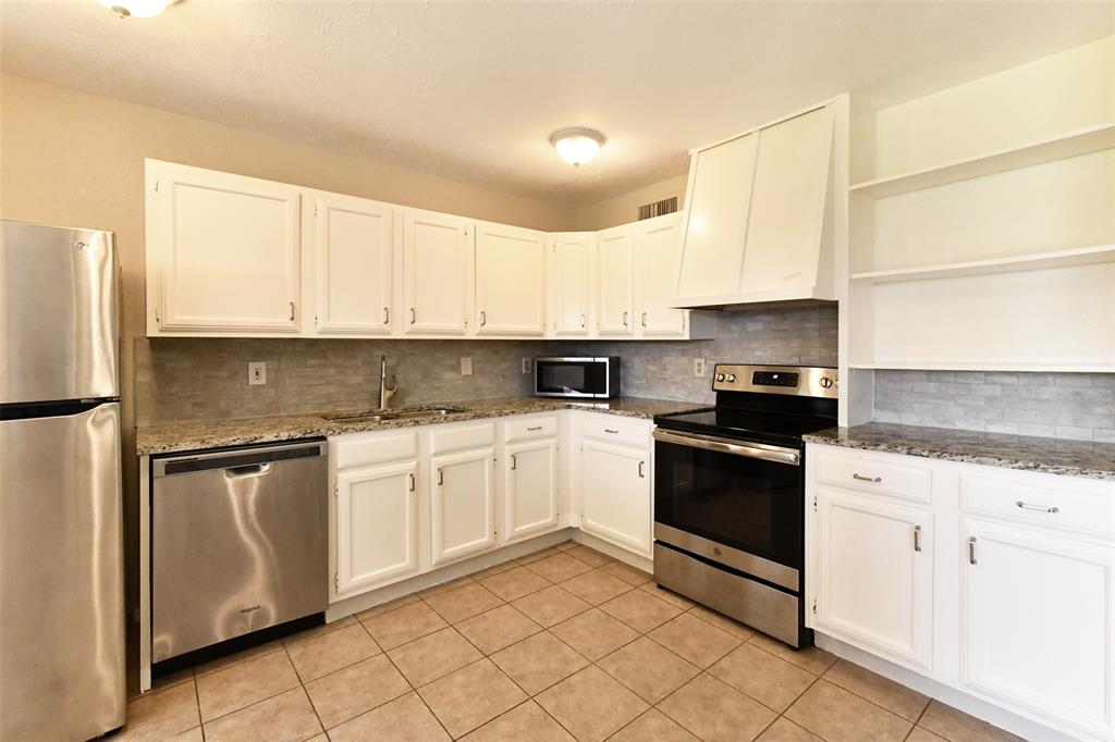 4113 Juneberry Street Fort Worth, TX 76137 - Photo 24 of 36 a kitchen with granite countertop white cabinets and white appliances