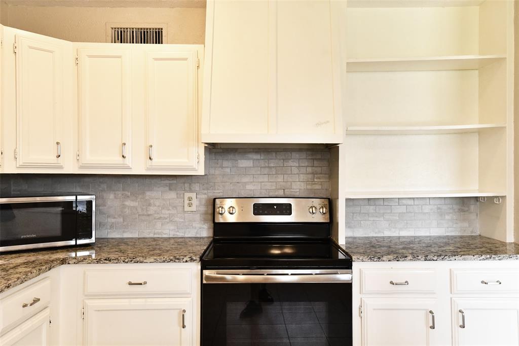 4113 Juneberry Street Fort Worth, TX 76137 - Photo 25 of 36 a kitchen with granite countertop a stove sink and cabinets