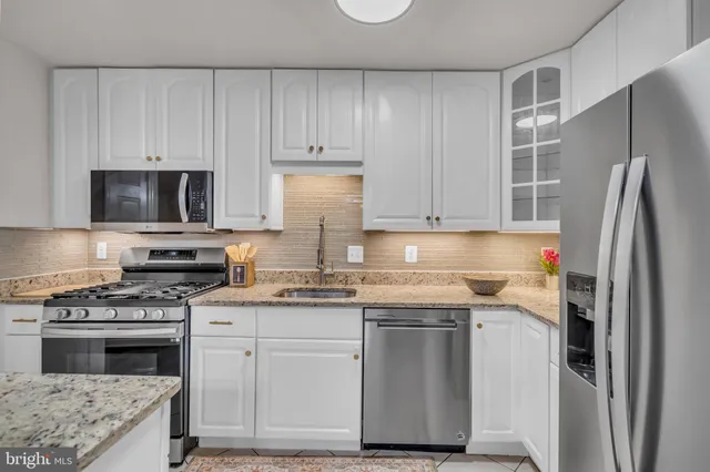 a kitchen with cabinets appliances and a counter space