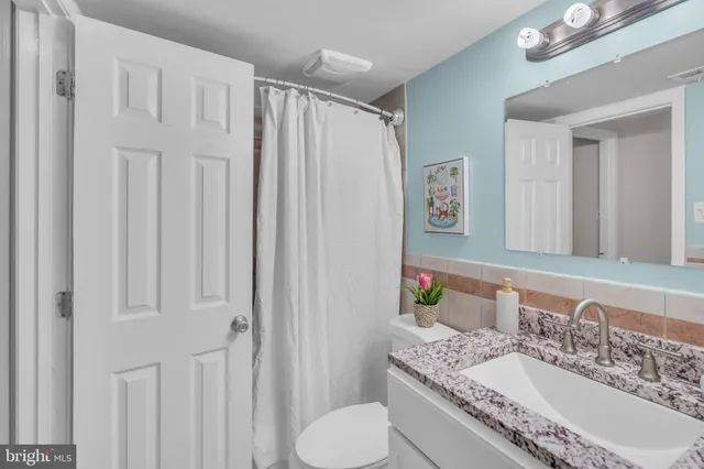 a bathroom with a granite countertop sink toilet and shower