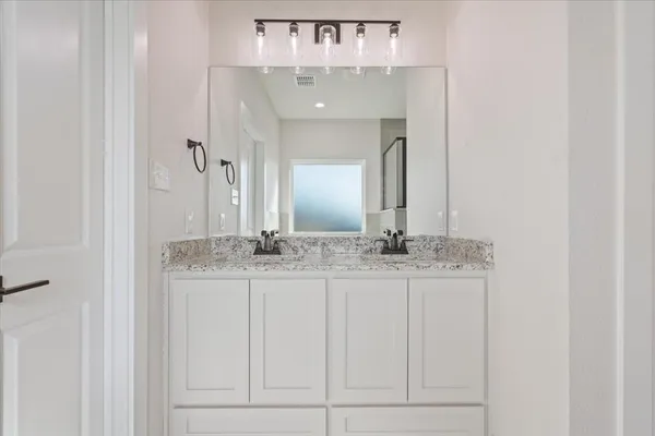 a bathroom with a granite countertop sink and a mirror