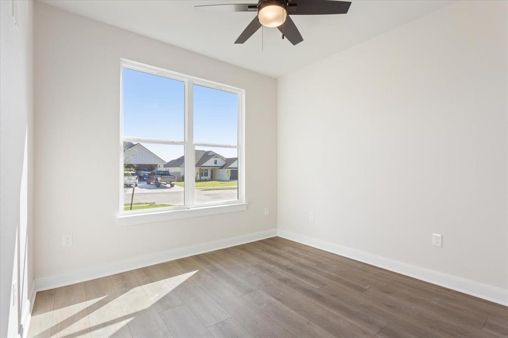 112 Great Trail Road Riesel, TX 76682 - Photo 20 of 28 an empty room with wooden floor fan and windows