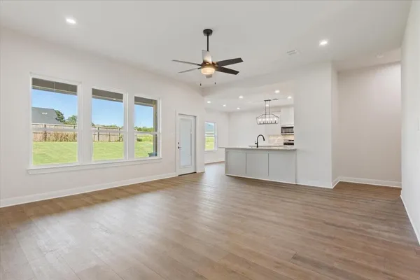 a view of an empty room with window and wooden floor
