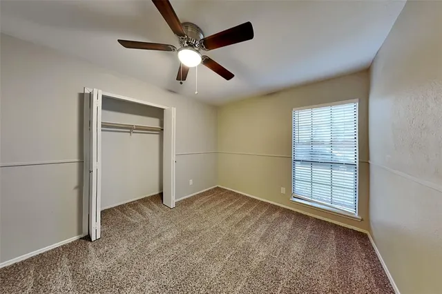 an empty room with closet and windows