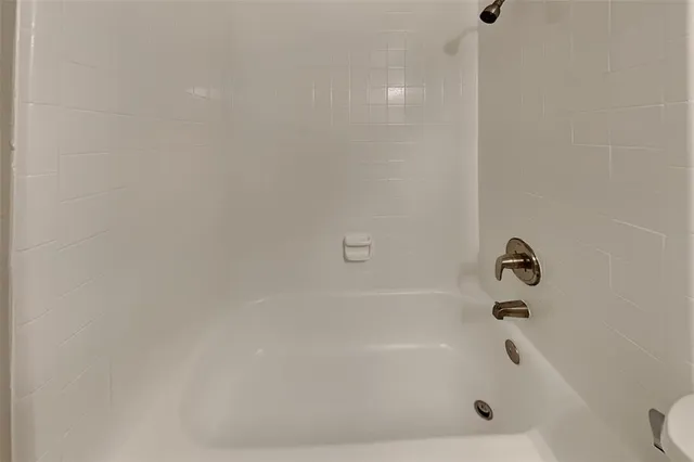 a bathroom with a granite countertop sink a toilet and mirror
