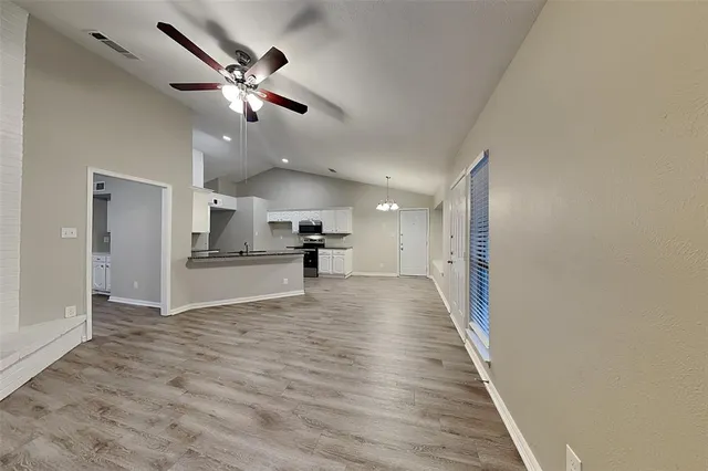 a view of empty room with wooden floor