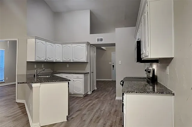 a kitchen with granite countertop a sink stove and refrigerator