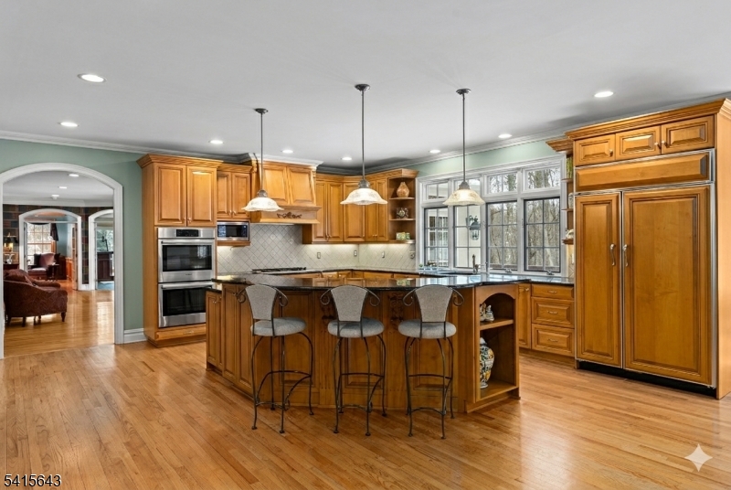 7 Timber Ridge Road Far Hills, NJ 07931 - Photo 8 of 48 a kitchen with granite countertop a table chairs stainless steel appliances and wooden floor