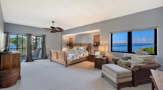 a spacious bedroom with a bed and a flat tv screen on dresser