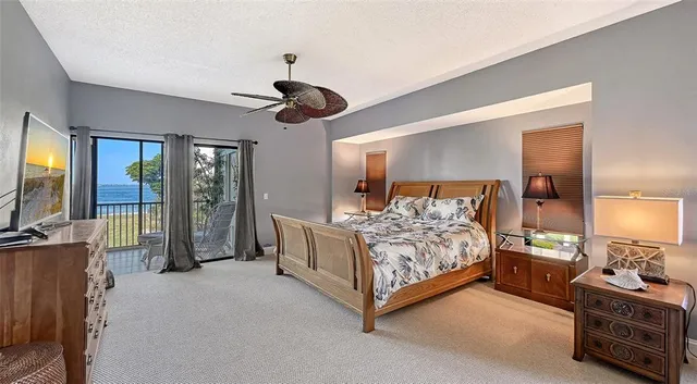 a bedroom with a large bed and ceiling fan