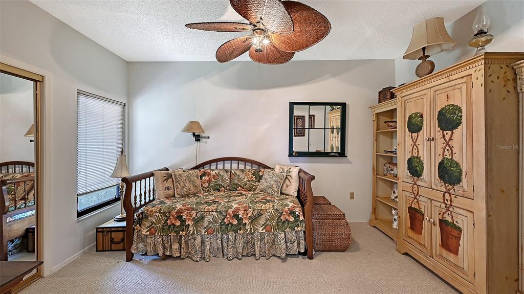 3850 Mariners Walk, Unit 714 Cortez, FL 34215 - Photo 21 of 59 a bedroom with a bed and a chandelier