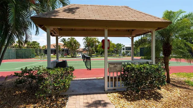 a view of a tennis ground with large trees