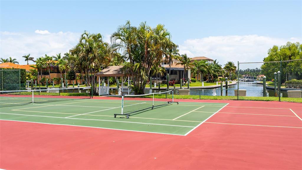 3850 Mariners Walk, Unit 714 Cortez, FL 34215 - Photo 32 of 59 a view of a tennis ground with large trees