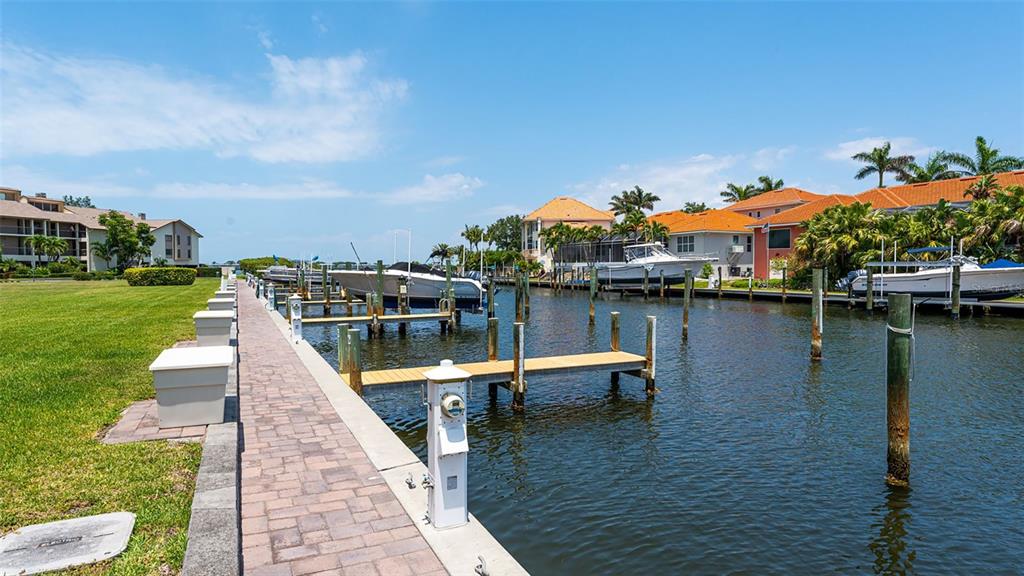 3850 Mariners Walk, Unit 714 Cortez, FL 34215 - Photo 37 of 59 a view of a lake with a table and chairs