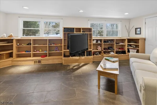 a living room with furniture a flat screen tv and floor to ceiling window