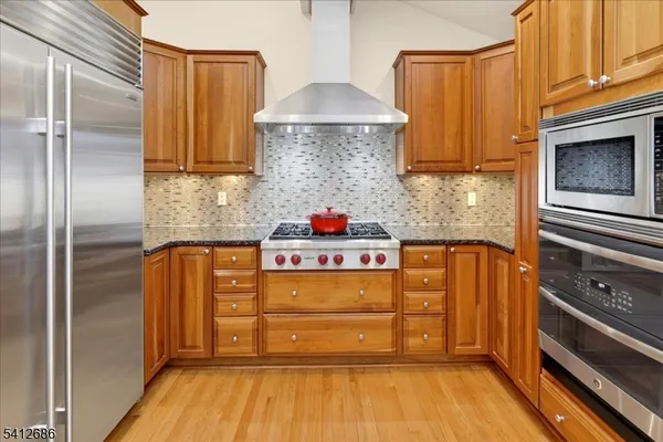 a kitchen with stainless steel appliances granite countertop a stove and a refrigerator