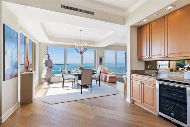 a kitchen with stainless steel appliances kitchen island granite countertop a refrigerator a stove top oven a sink dishwasher and white cabinets with wooden floor