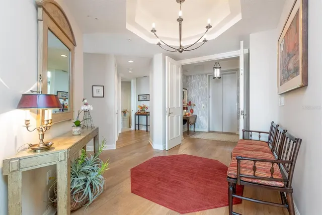 a open kitchen with stainless steel appliances granite countertop a stove top oven a refrigerator and a dining table with wooden floor