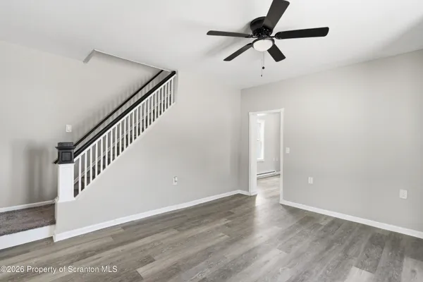 a view of an empty room with wooden floor