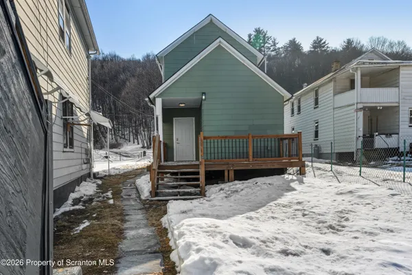 a view of house with backyard and sitting area