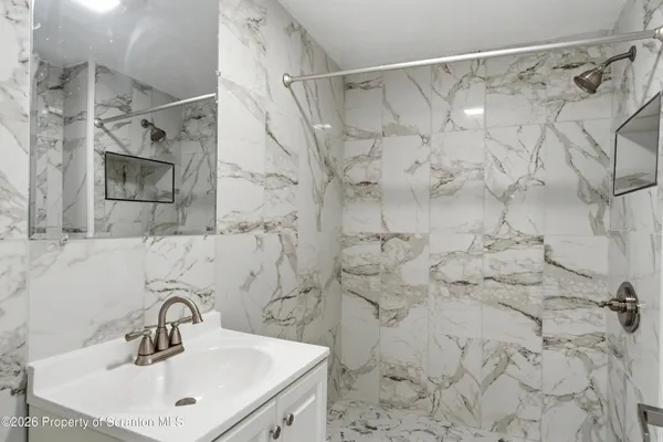 a bathroom with a sink mirror and shower