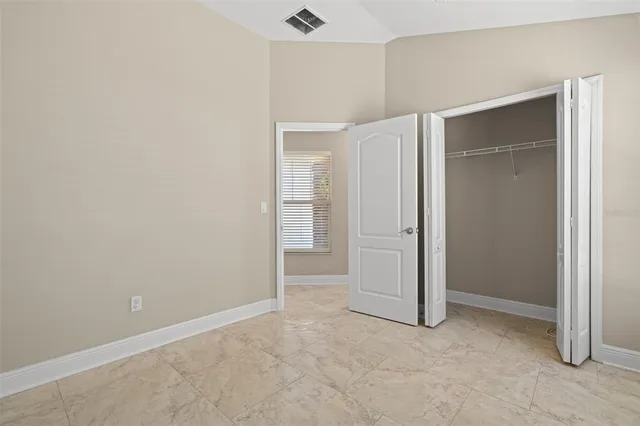 an empty room with closet and a window