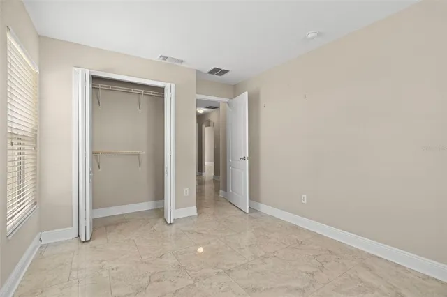 an empty room with closet and a window