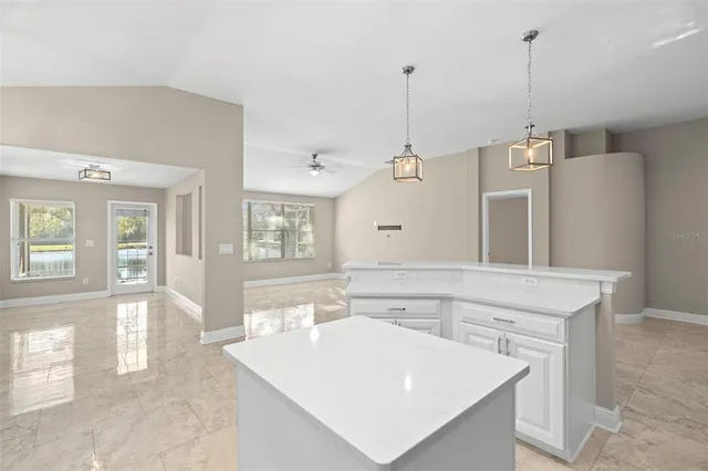 a kitchen with a sink a center island a counter space and a window