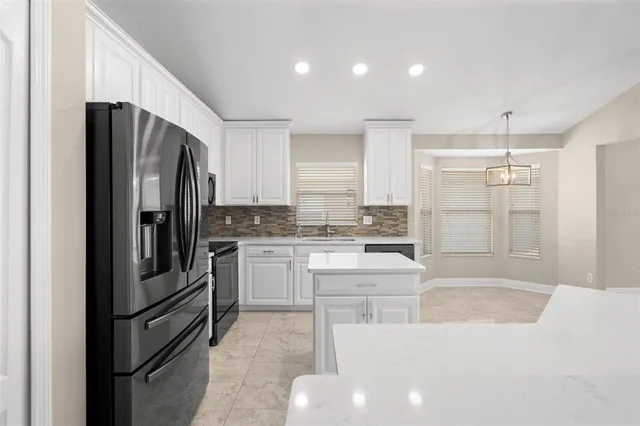 a kitchen with a refrigerator and a stove top oven