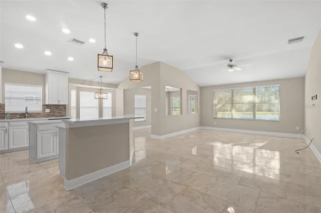 a open kitchen with kitchen island white cabinets and white appliances