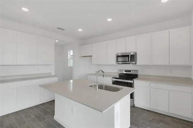 a kitchen with stainless steel appliances granite countertop a sink stove and microwave