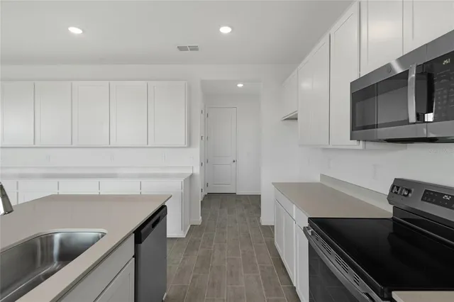 a kitchen with stainless steel appliances a sink stove and microwave