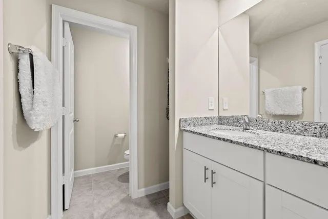a bathroom with a granite countertop toilet sink and a bathtub
