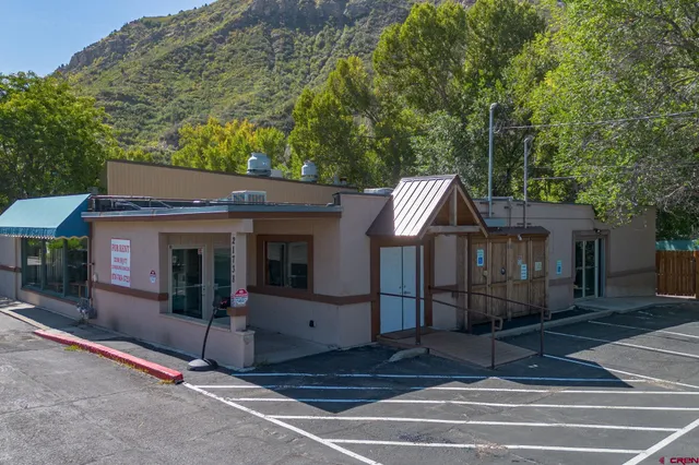 a view of a house with a patio and wooden fence
