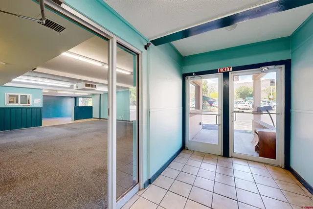 a large space with wooden floor and windows