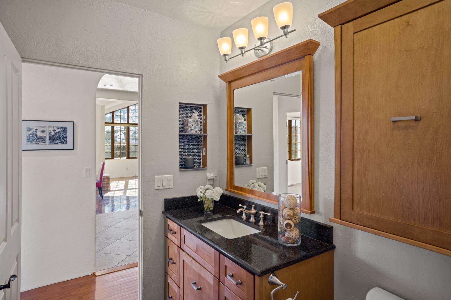 12365 Saddle Road Carmel Valley, CA 93924 - Photo 41 of 65 a bathroom with a granite countertop sink a mirror and a shower