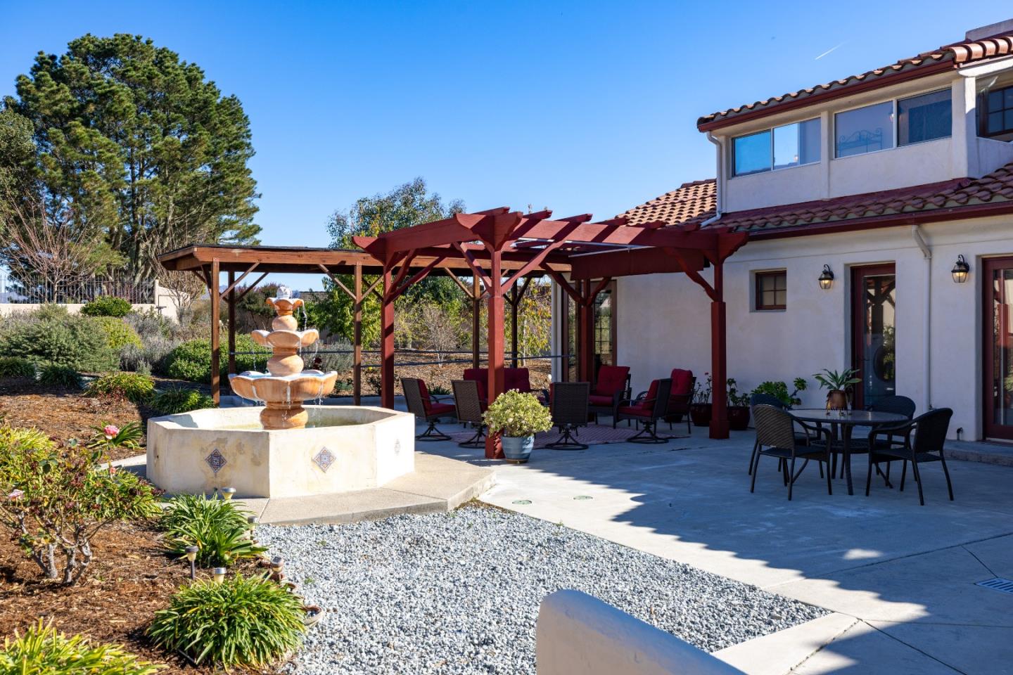 12365 Saddle Road Carmel Valley, CA 93924 - Photo 53 of 65 a view of a patio with couches table and chairs under an umbrella with a patio