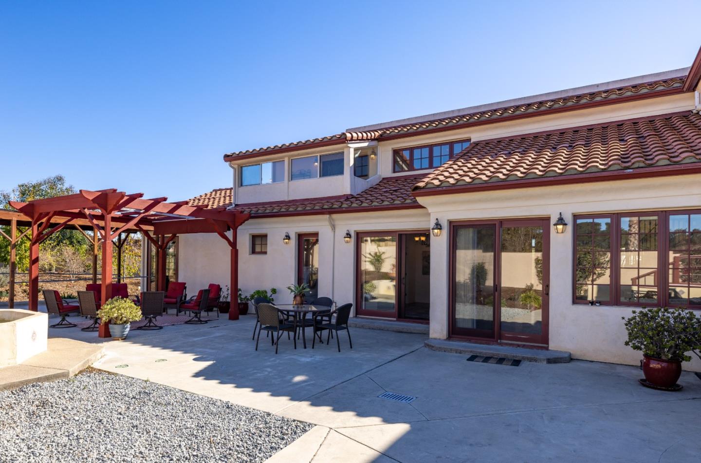 12365 Saddle Road Carmel Valley, CA 93924 - Photo 56 of 65 a view of a patio with table and chairs potted plants and floor to ceiling window