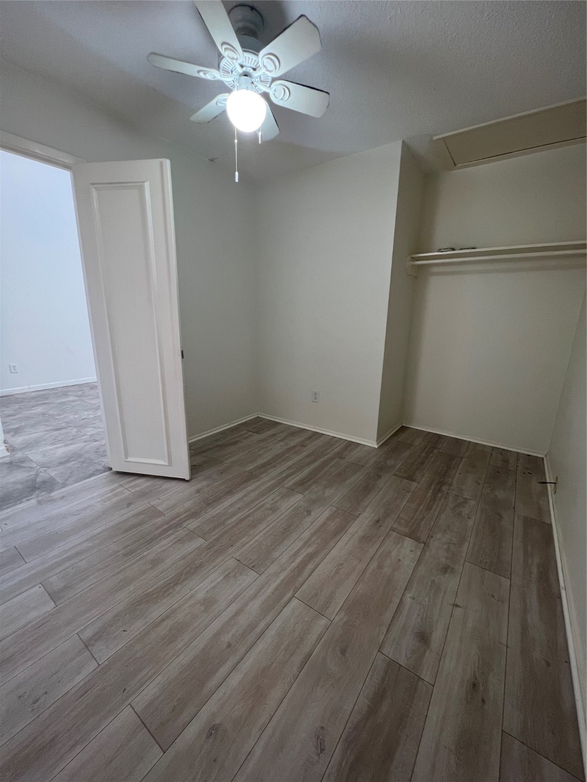 12550 Newbrook Drive Houston, TX 77072 - Photo 3 of 15 an empty room with wooden floor and ceiling fan